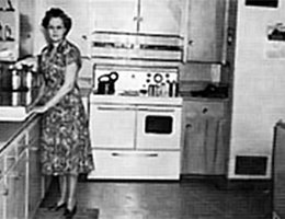 Eventually, electricity made life easier for everyone, including this woman and her family in a rural farmhouse in Phelps County, Nebraska. She stands in her kitchen with her new electric appliances.