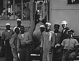 World War II African American Experience: boarding a Navy bus to go to work. These same "buses" were used to take African American men to Omaha on the weekends. US Naval Ammunition Depot, Hastings, Nebraska; circa 1944.