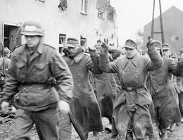 The first group of prisoners taken in Hilforth, Germany are marched to the rear by the 9th Army MPs (military police), February 26, 1945
