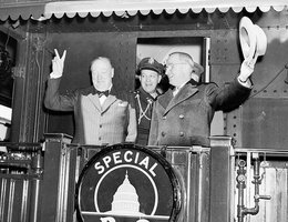 President Harry Truman waving his hat and Winston Churchill flashing his famous "V for Victory" sign from the rear platform of a special Baltimore & Ohio train en route to Fulton, Missouri for Churchill’s "Iron Curtain" speech, March, 1946