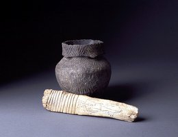 This Lower Loup culture (or Pawnee) paddle was made from a buffalo vertebral spine and decorated with a stylized human figure