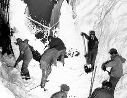 Snow plow assisted by shovelers to clear train tracks, Winter 1948-49