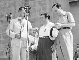 Gov. Dwight Griswold presents Abbott and Costello with an ear of corn as a memento of their trip to Nebraska to help sell war bonds