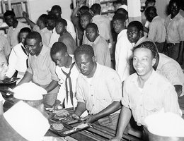 The need for bombs and other ordnance brought African American recruits and civilian workers to Hastings. Cafeteria lines in mess hall at Naval Barracks Area, US Naval Ammunition Depot, Hastings, Nebraska; circa 1944.