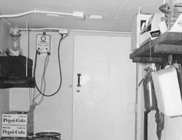 Fire extinguisher, first aid kit, stored water, and other supplies in personnel fallout shelter at the Roberts Dairy Company Farm