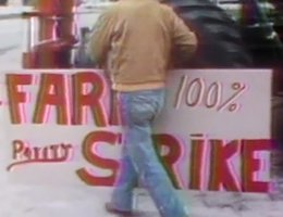 Farmer carrying sign as he walks by a tractor: "Farm Strike — 100% Parity"; Washington, D.C.